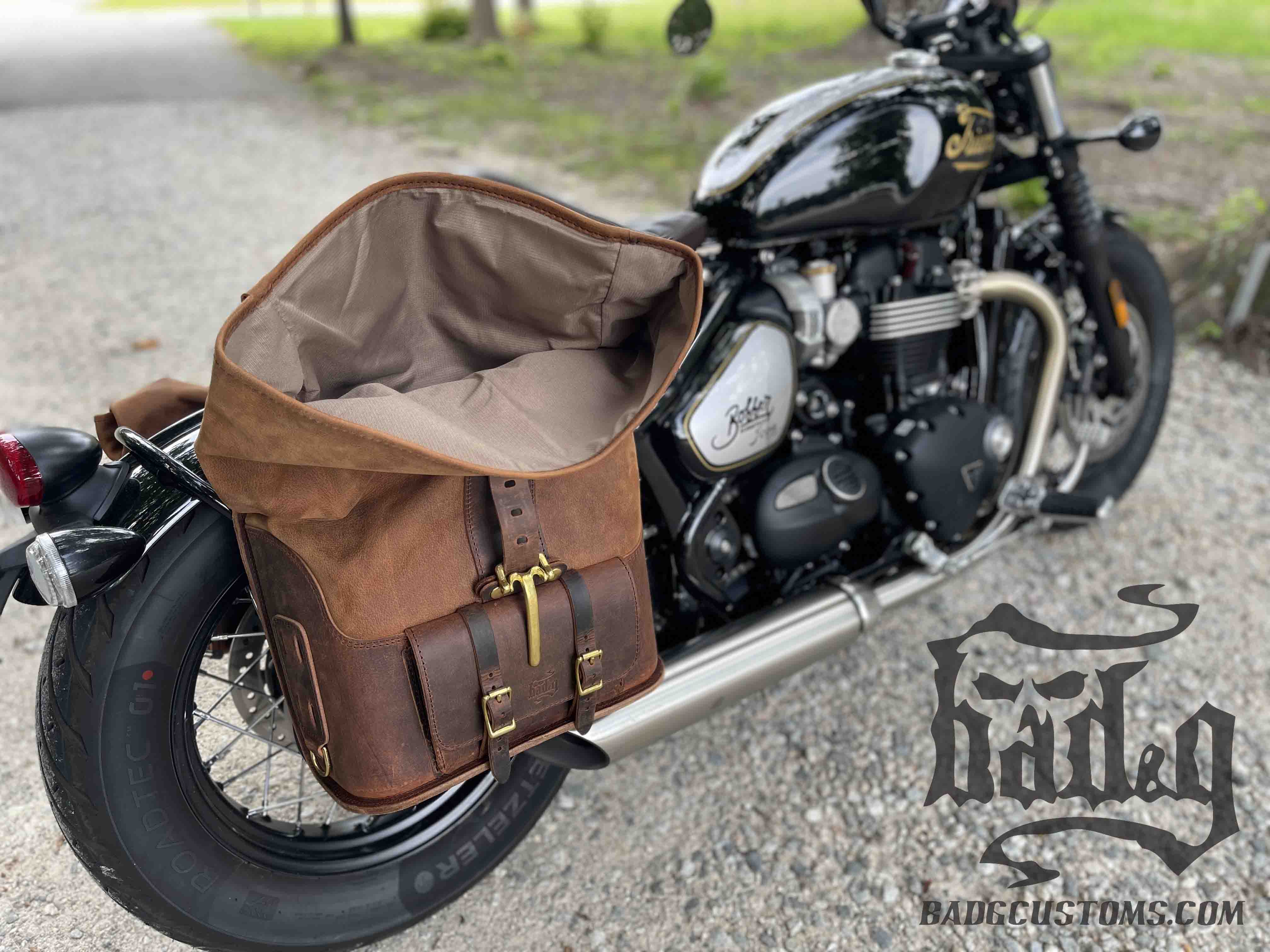 Triumph Bonneville Bobber Panniers Rolltop Swingarm Saddlebags. Hand crafted in USA with premium veg tan water buffalo leather, waterproof liners and solid brass hardware. BAD&G Customs TBP01