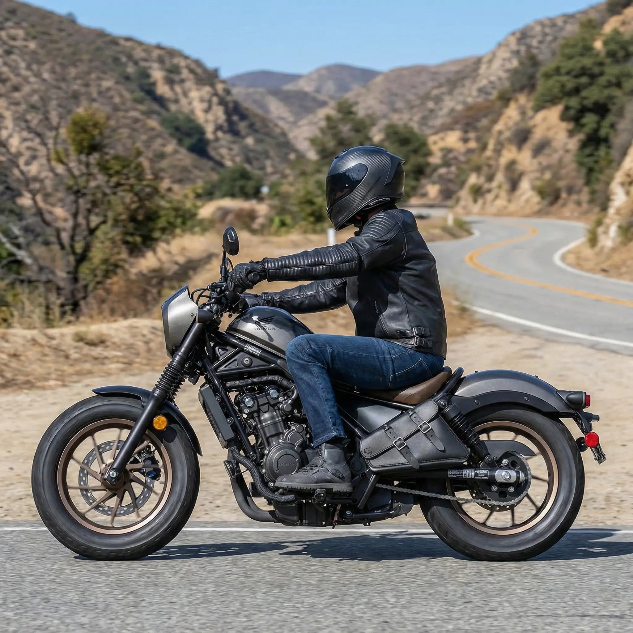 Person riding a Honda Rebel motorcycle on a mountain road